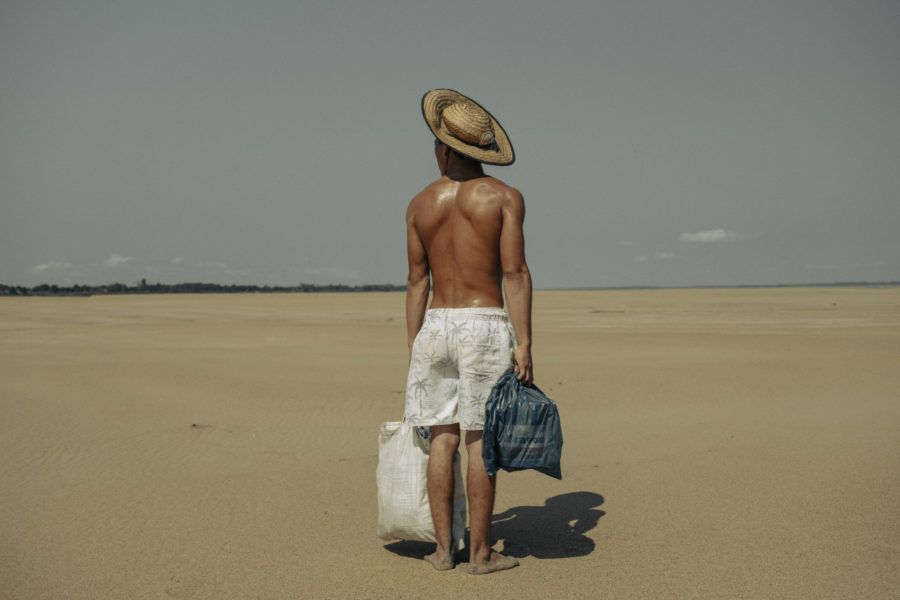 A young man named Cordeiro Freitas helps his mother carry food from the point where boats dock to the fishing community of Maracapuru, walking nearly 2 kilometers under the intense sun.

-

Droughts in the Amazon, especially in the Amazon, Negro, and Solimões rivers, are reaching alarming levels. One of the major tributaries of the Amazon River has recorded its lowest level in history, as reported by Brazil's geological service, reflecting a severe drought that has devastated the Amazon rainforest and other parts of the country.

At the beginning of October, the level of the Negro River at the port of Manaus was 12.66 meters, compared to its normal level of around 21 meters. This is the lowest level recorded since measurements began 122 years ago. 

Water levels in the Amazon naturally fluctuate between the rainy and dry seasons, but this year's dry season has been much more severe than usual. All major rivers in the Amazon basin are at critical levels, including the Madeira River, the longest tributary of the Amazon.

This phenomenon, associated with climate change, threatens not only biodiversity and river ecosystems but also the livelihoods of local communities that depend on these rivers for sustenance. Many of these communities have been cut off, and their boats have become stranded on large sandbanks. Due to the projected recurrence of droughts in the coming years, several communities are considering abandoning their territories and migrating to cities.